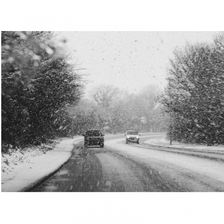 Two cars driving on a snowy road