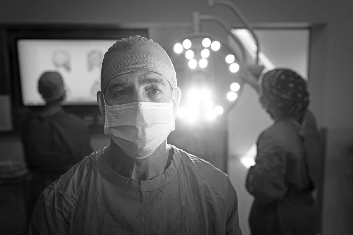 Surgeon in operating room looking directly at camera.