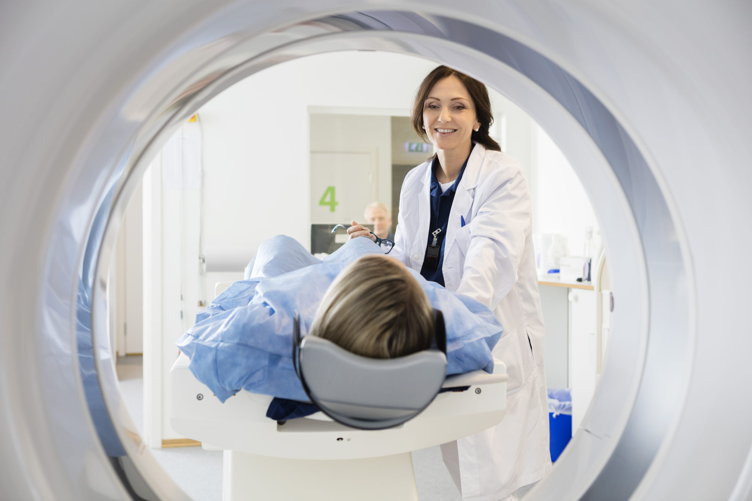 medical imaging requisition management - patient and technologist at CT scanner