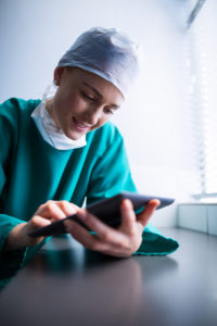 surgeon uses tablet to check surgical waitlist management solution