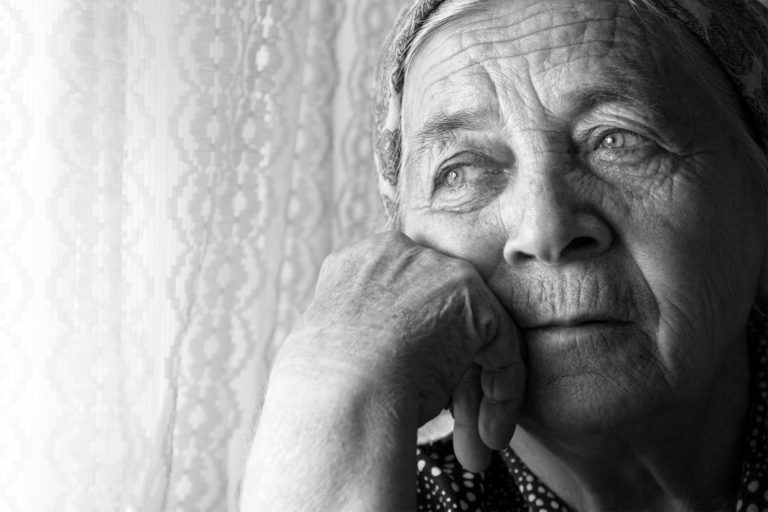 Black and white photo of old woman's face looking thoughtfully into the distance
